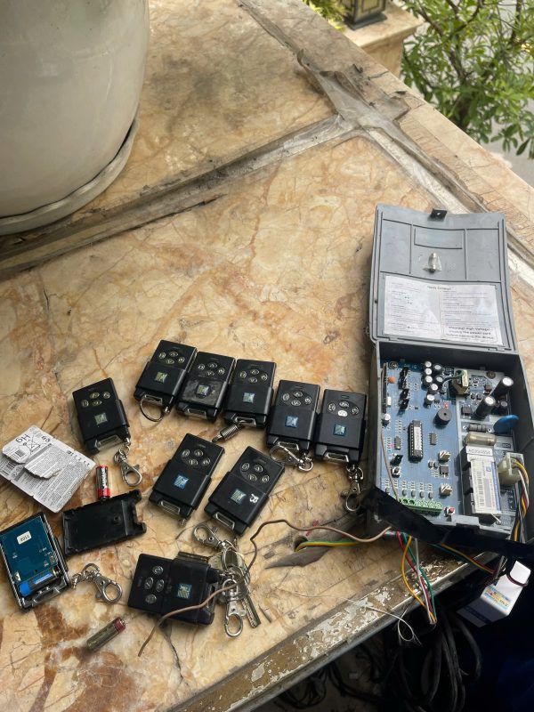 Sửa cửa cuốn: hộp điều khiển và các remote cửa cuốn trên bàn kiểm tra
