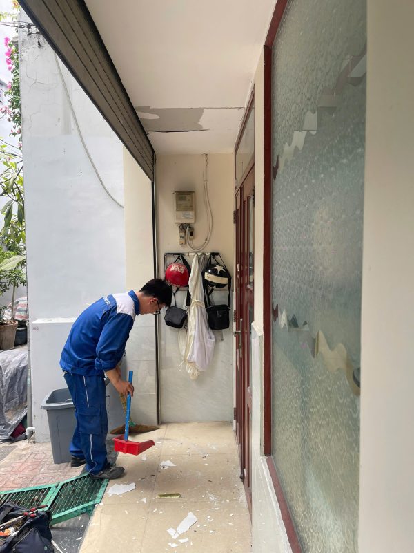 Sửa cửa cuốn: kỹ thuật viên chuẩn bị dụng cụ tại mép cửa cuốn