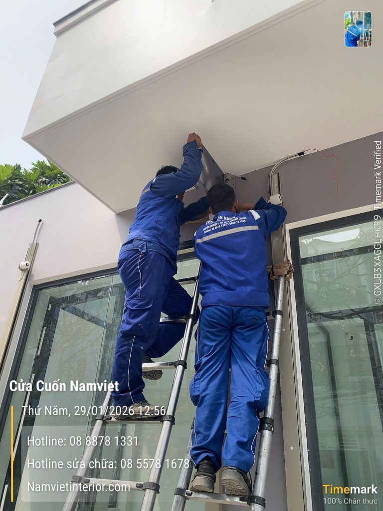 Hai thợ Namviet thao tác ở hộp che phía trên cửa cuốn – Cửa cuốn Namviet TP.HCM